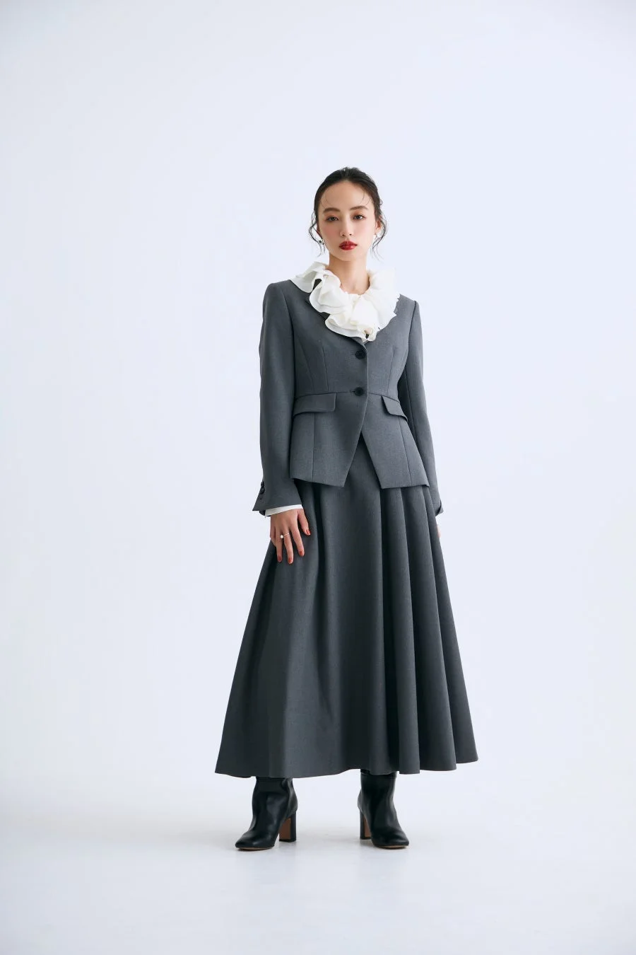 グレーのスーツセットアップを着用した女性モデル