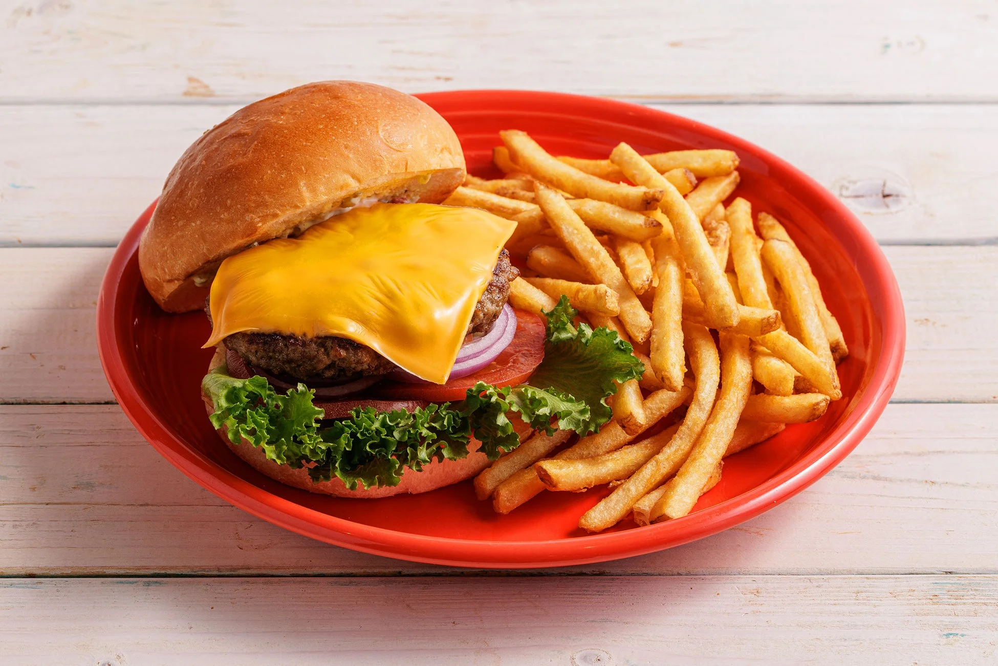とろけるチーズが乗ったハンバーガーとフライドポテト