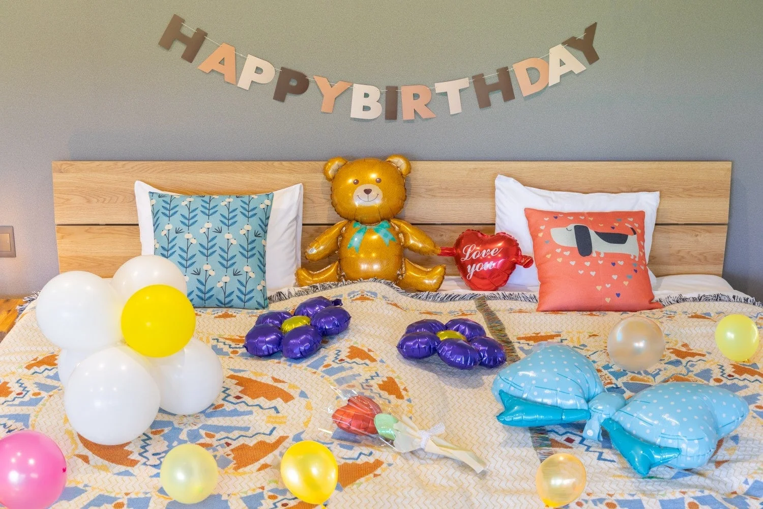 ベッドの上に誕生日を祝うための飾り付けがされた写真