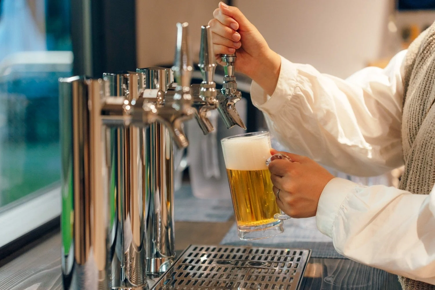 ビアサーバーからグラスにビールが注がれている様子